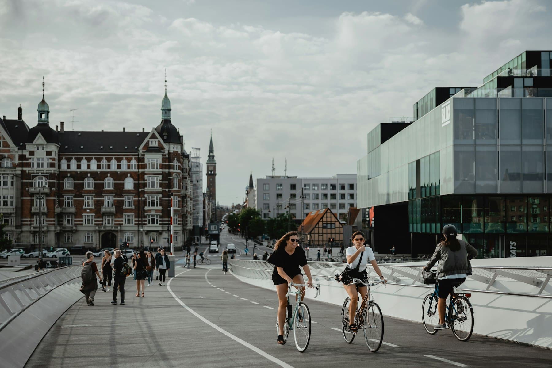 Cyklister og fodgængere på en sti mellem bygninger i København